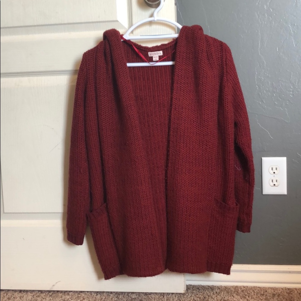 Red/maroon cardigan.